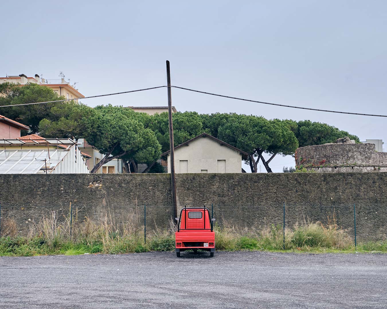 Piccola Ape 50 rossa in un parcheggio vuoto