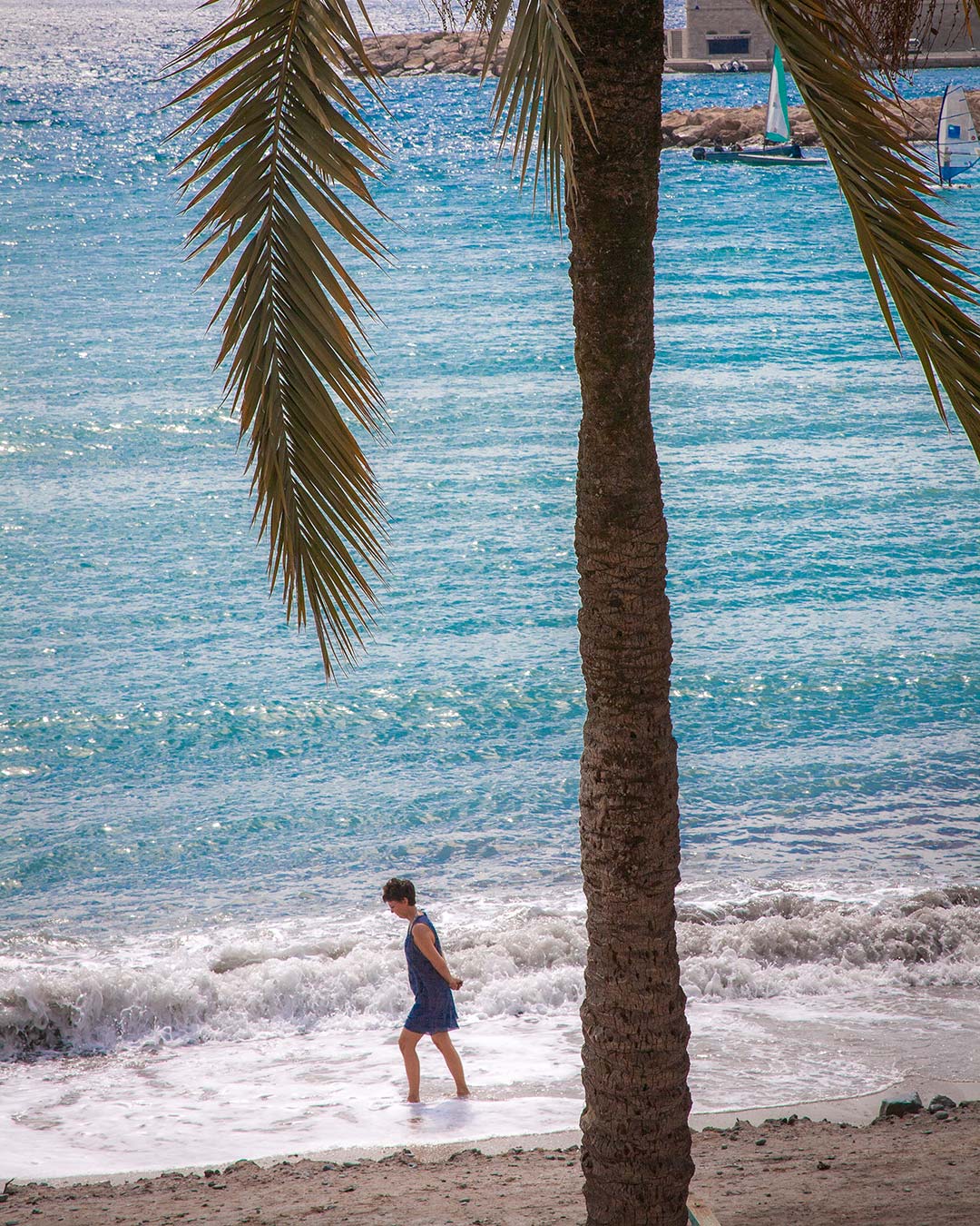 Donna che cammina sola lungo una spiaggia.