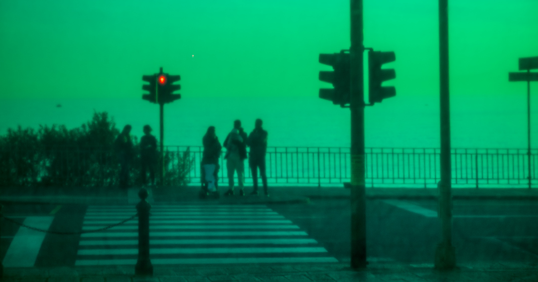 figure in silhouette di fronte a un semaforo