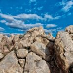 Scogli e cielo azzurro con nuvole bianche